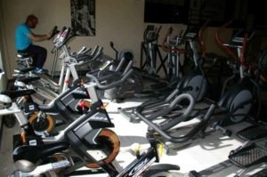Muchas bicis estáticas libres y un señor pedaleando. Gimnasio Belvis, jarama, fuentelsaz